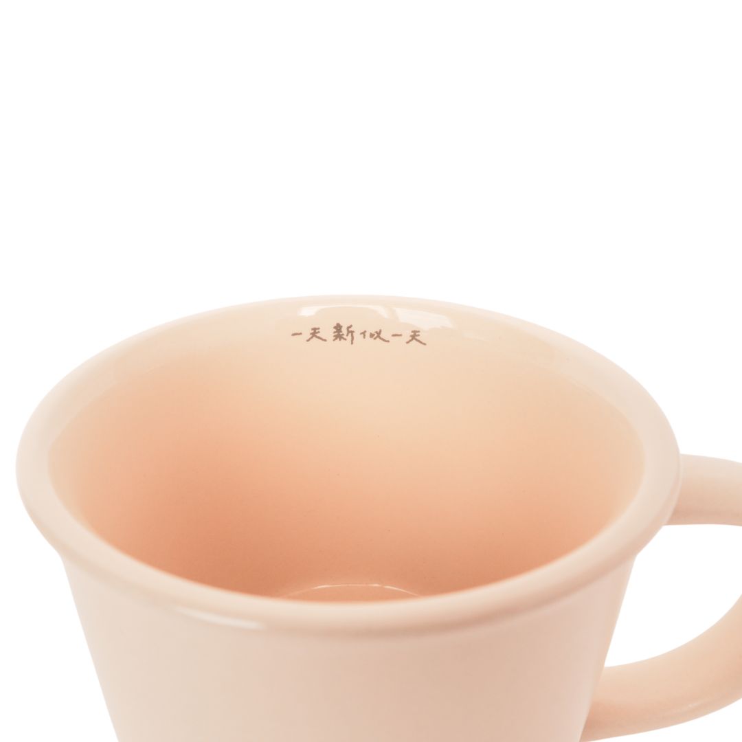 新的一天陶瓷杯杯口內側細節圖,淡粉色杯內上緣印有「一天新似一天」字樣。