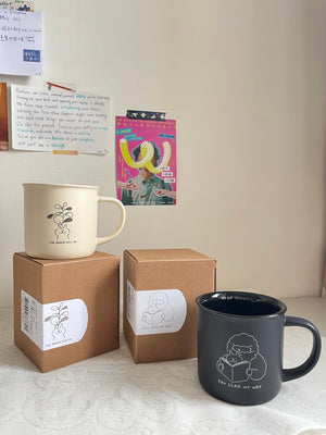 陶瓷杯系列情境展示,兩款不同配色杯款與品牌包裝盒一同擺放於桌面,呈現系列插畫設計與包裝風格。