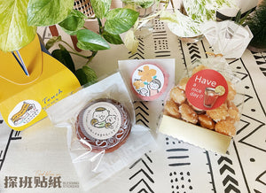 《探班貼紙 Blessing Sticker》點心包裝應用照,祝福貼紙貼在餅乾、點心袋與黃色提盒上,呈現不同造型貼紙搭配甜點禮物的效果。