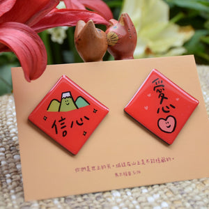 信心愛心春聯磁鐵組實拍圖，兩枚紅色菱形磁鐵分別印有「信心」與「愛心」字樣，搭配馬太福音5章14節經文卡。