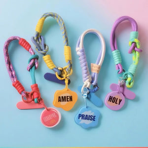 手機短掛繩系列款式總覽，展示多款繽紛撞色掛繩與 HOPE、AMEN、PRAISE、HOLY 等信仰文字吊牌，搭配手機夾片與掛扣設計。