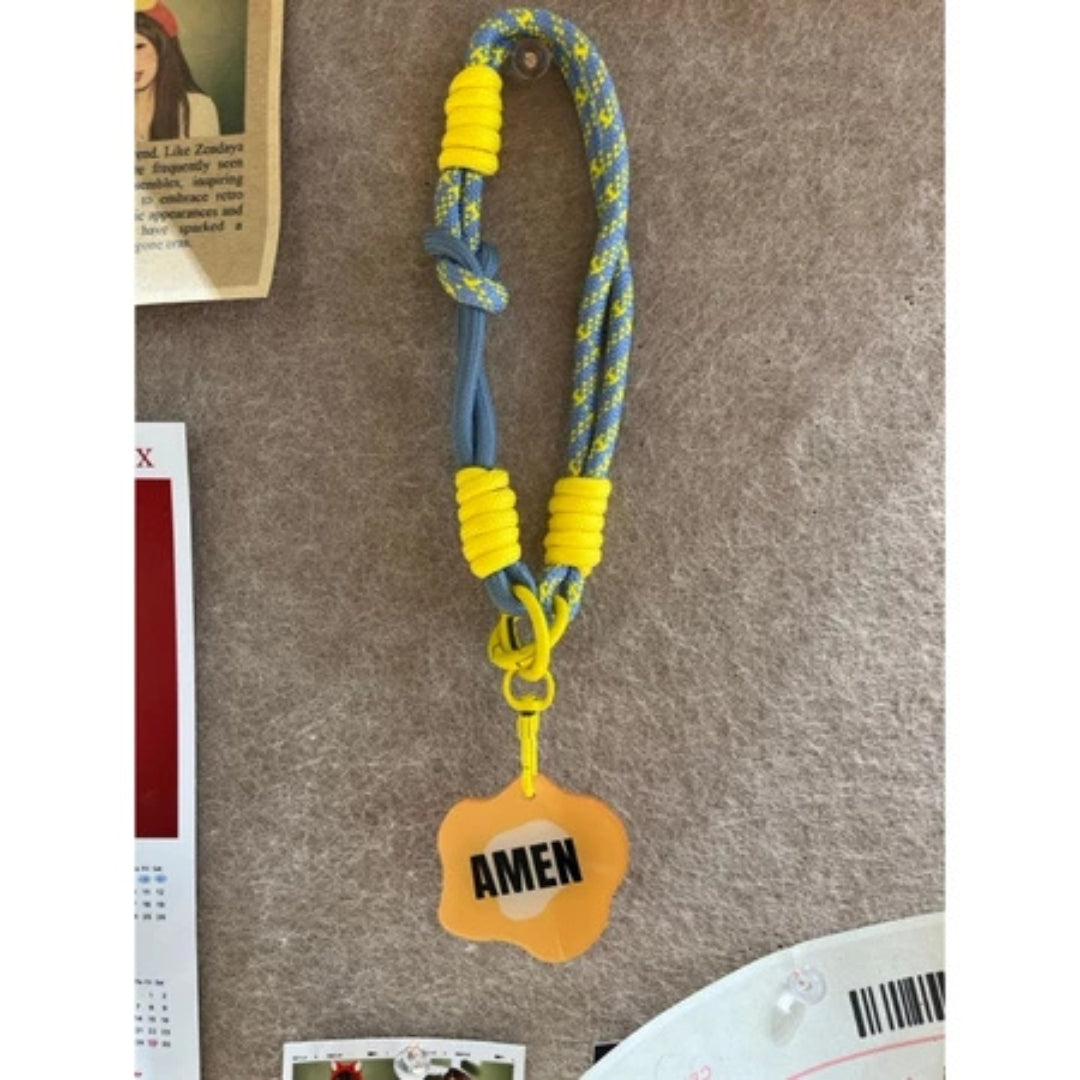 黃色 AMEN 款手機短掛繩商品展示，藍灰與黃色撞色編織繩搭配橘黃色 AMEN 吊牌。