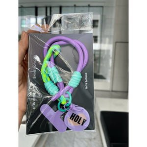 紫色 HOLY 款手機短掛繩包裝展示，紫色與螢光綠撞色編織繩搭配紫色手機夾片及 HOLY 圓形吊牌。