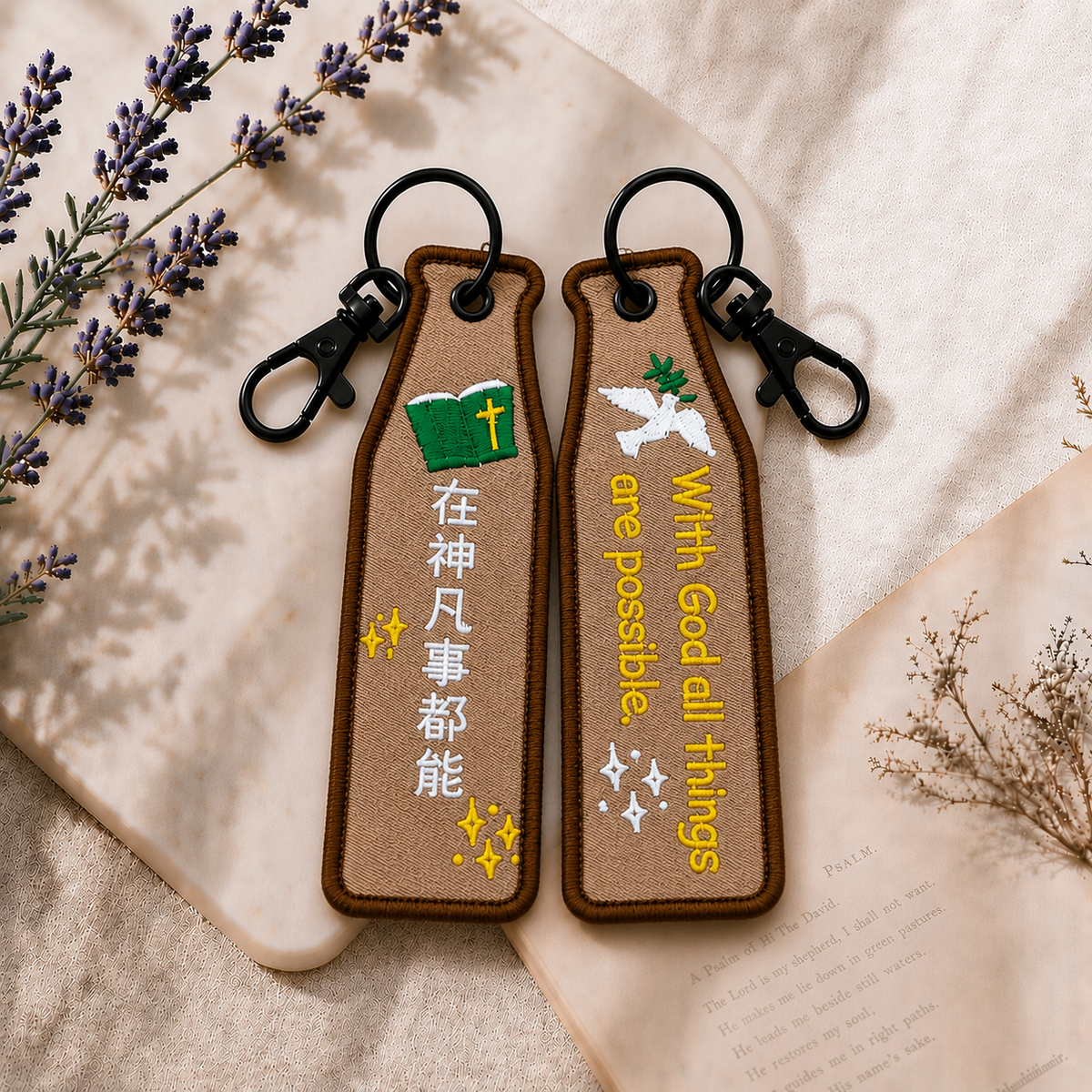 神都能咖色瓶安同行刺繡吊飾雙面展示，一面為中文「在神凡事都能」字樣，另一面為英文 With God all things are possible. 字樣，搭配聖經、白鴿與星光插畫及黑色掛鉤。
