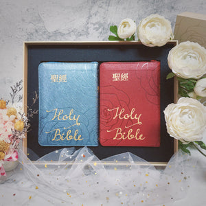 豪華款婚禮聖經禮盒商品展示，藍色與紅色 Holy Bible 拉鍊聖經並列於禮盒中，搭配白色花卉婚禮情境佈置