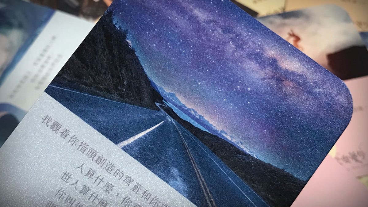 《天父樂愛你》A 款恩典卡近拍，圖卡上半部是紫藍色星空下延伸至遠方的道路，下半部印有祝福文字，展示卡片圓角與印刷質感。